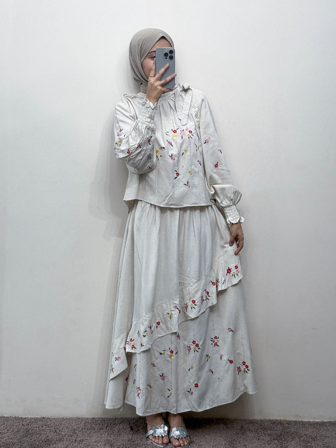 Person wearing a floral outfit against a plain background