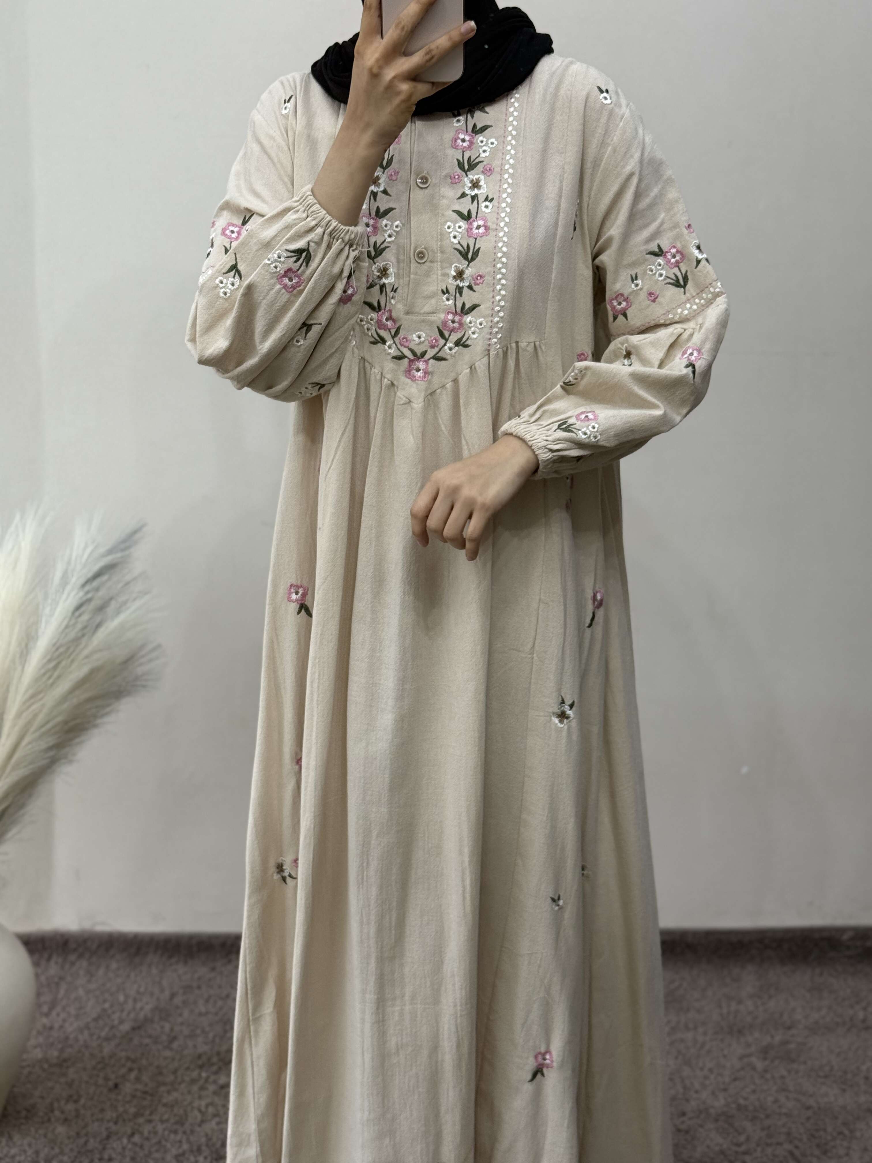 Beige dress with floral embroidery on a plain background