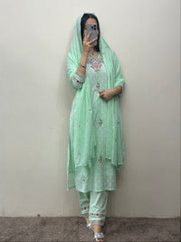 Person wearing a light green traditional outfit with a matching dupatta against a plain background