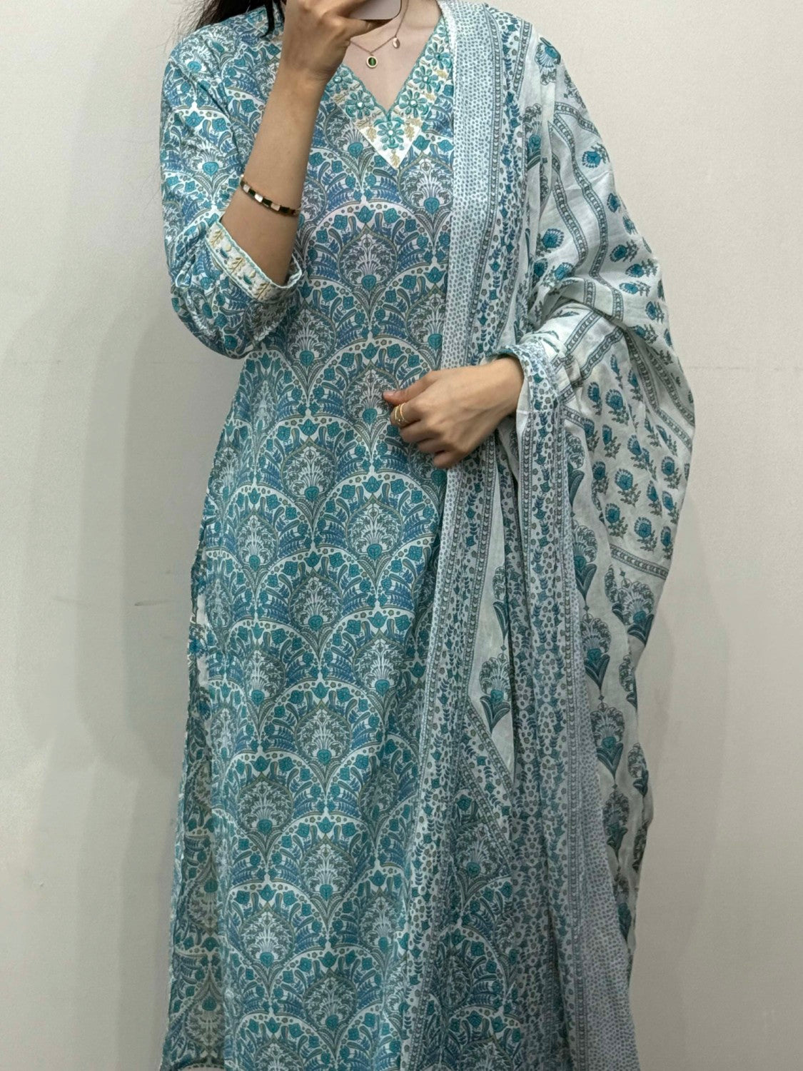 Person wearing a blue and white patterned outfit against a plain background