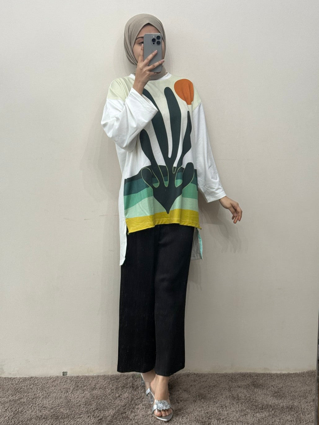 Person wearing a colorful top and black pants in front of a mirror.