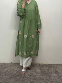 Person wearing a green floral outfit against a plain background
