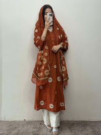 Person wearing a brown floral patterned outfit against a plain background