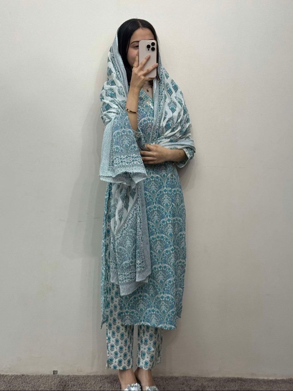 Person wearing a patterned outfit against a plain background